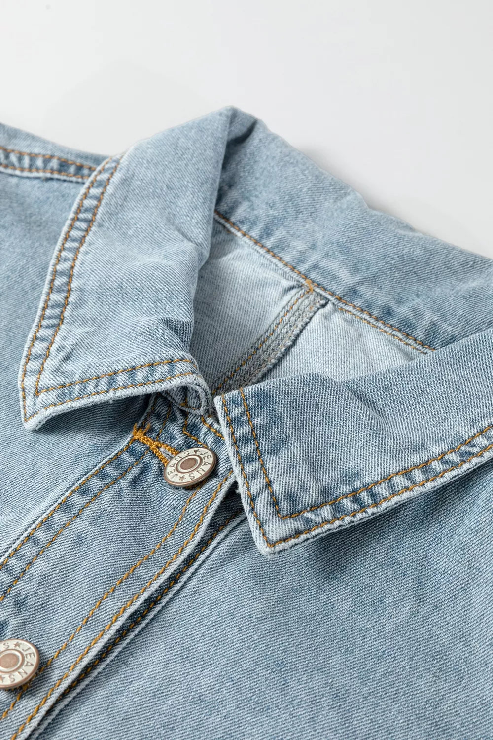 Side view of the denim jacket with the hem cinched in