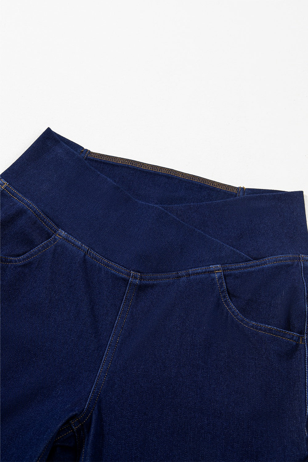 Angled view of navy flare jeans on model