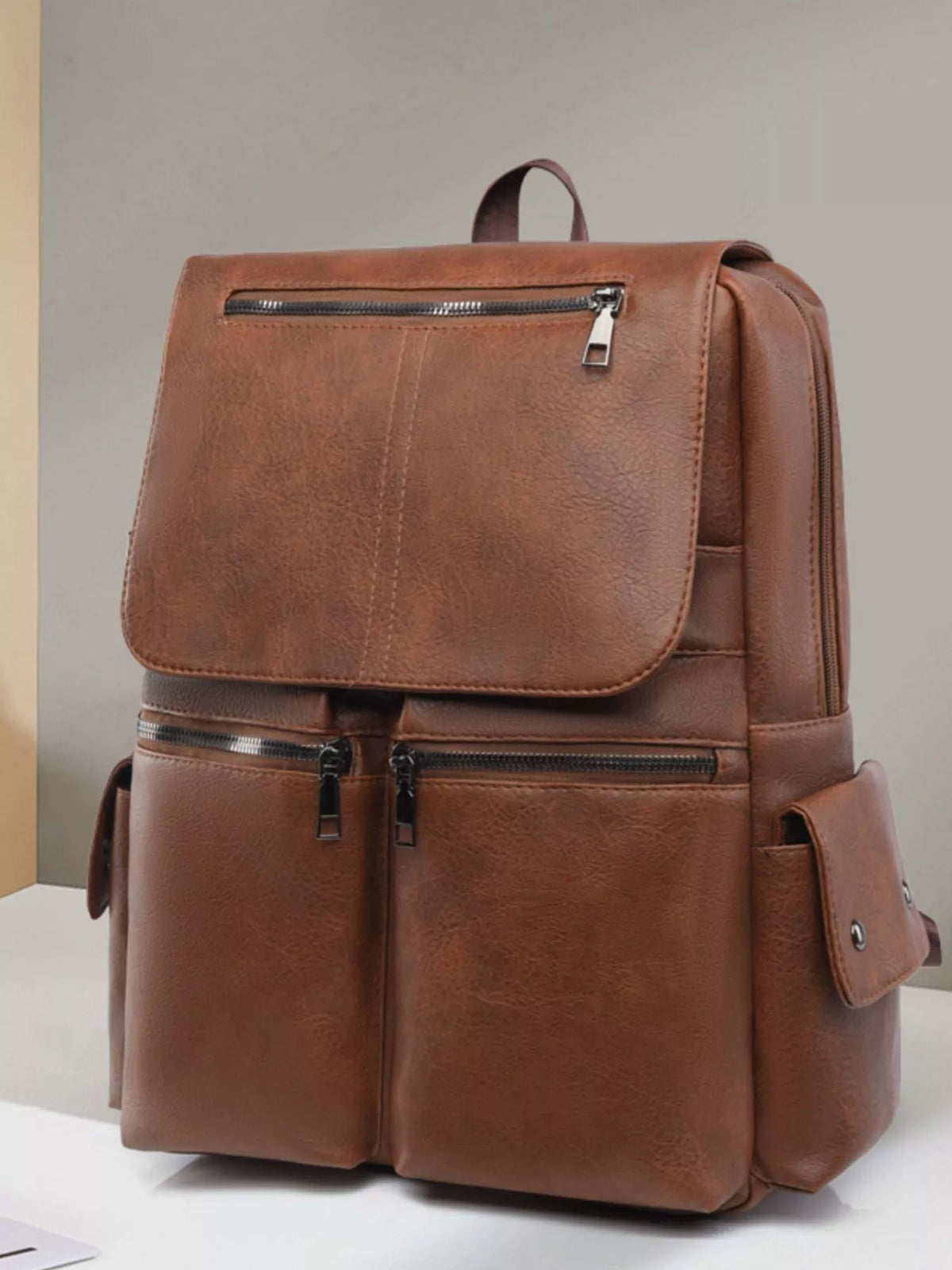 Faux leather flapover backpack worn on the back