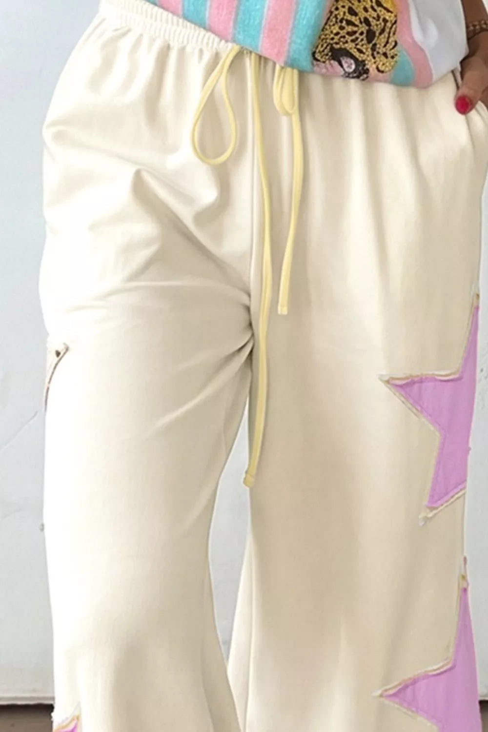 Wide leg cream pants side view showing star print