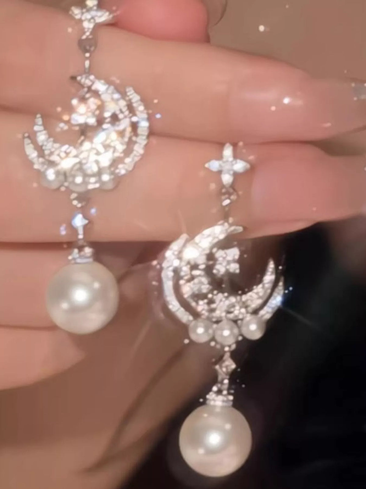 Moon and star pearl dangle earrings in silver tone, side view