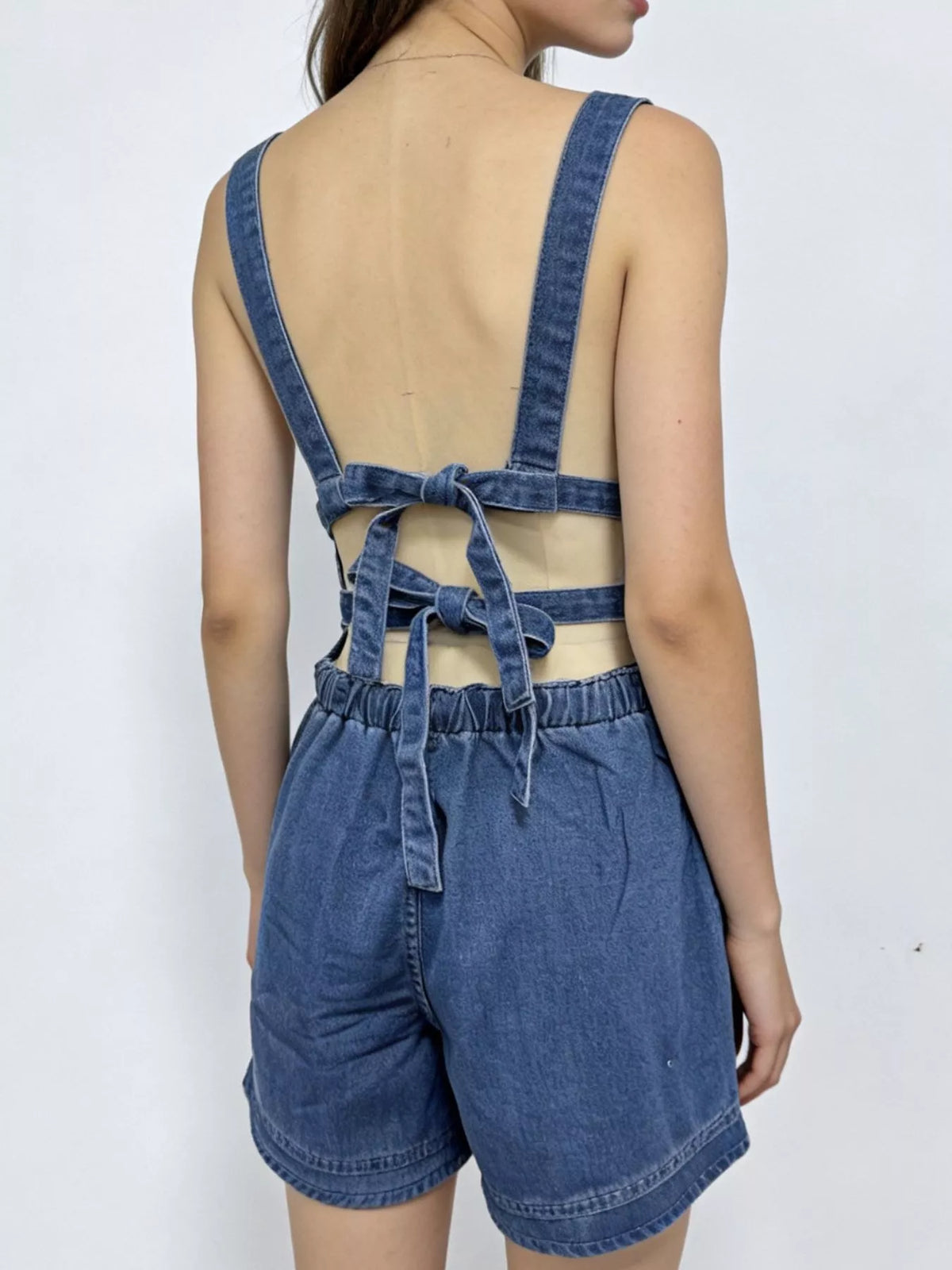 Dark blue denim overall shorts styled full length view