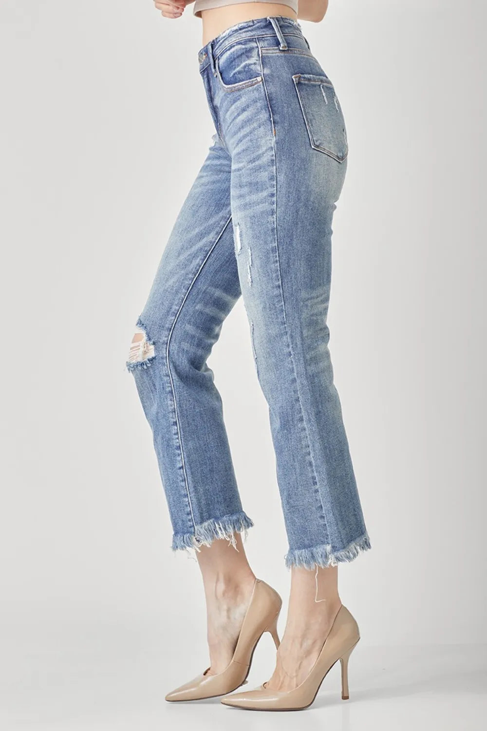 Close up of distressed detailing and raw hem on RISEN jeans