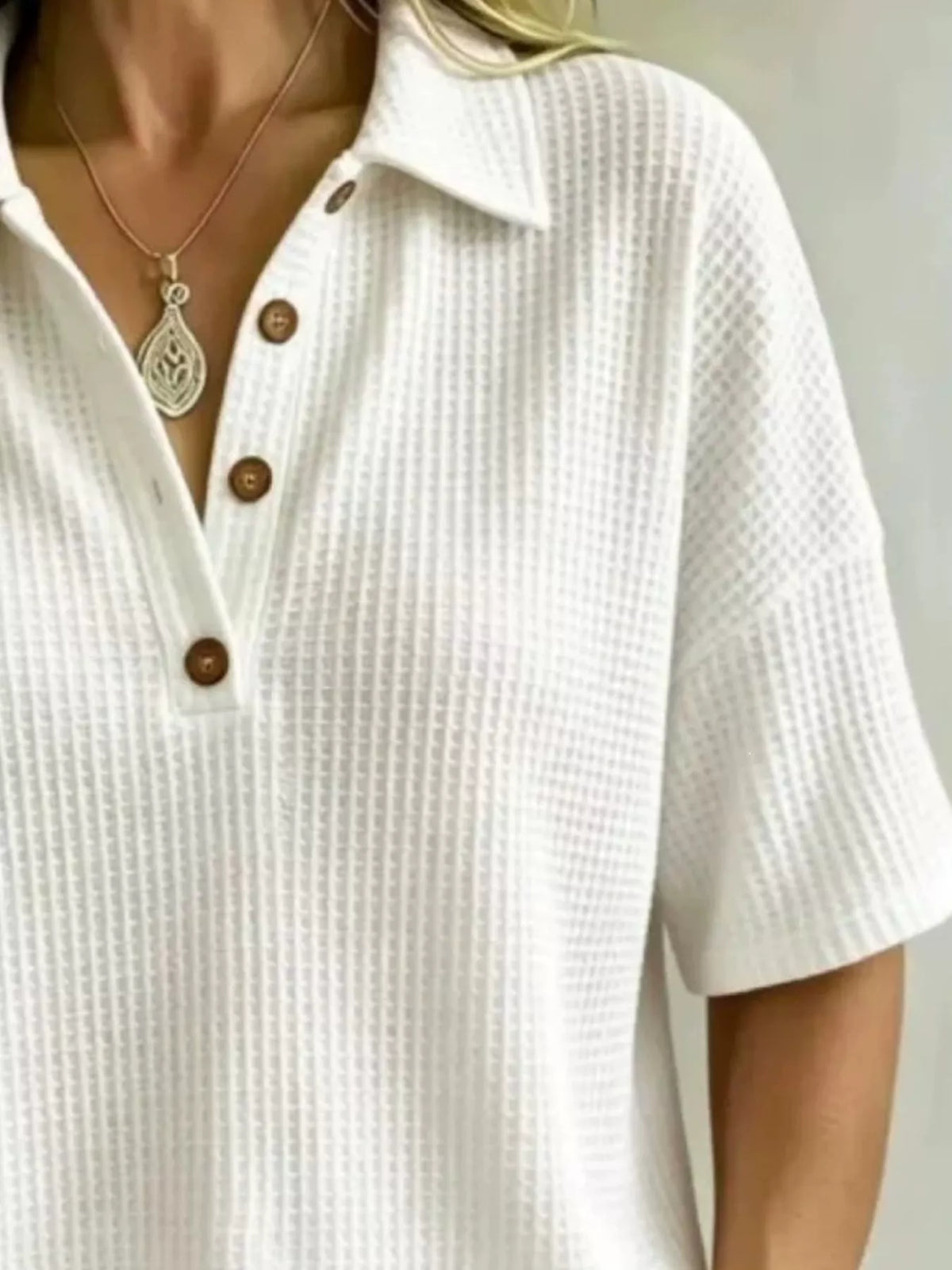 Waffle knit polo top shown from the front with the placket buttoned