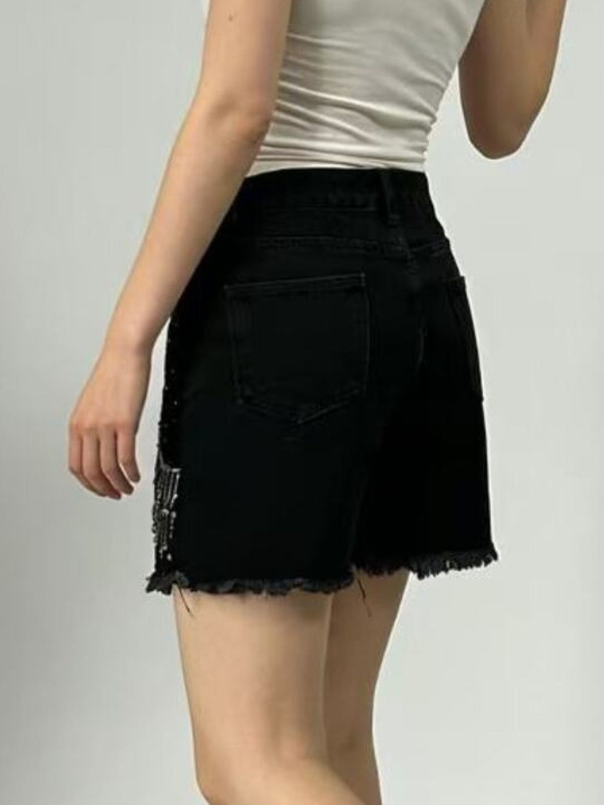 Close up of raw hem on denim shorts