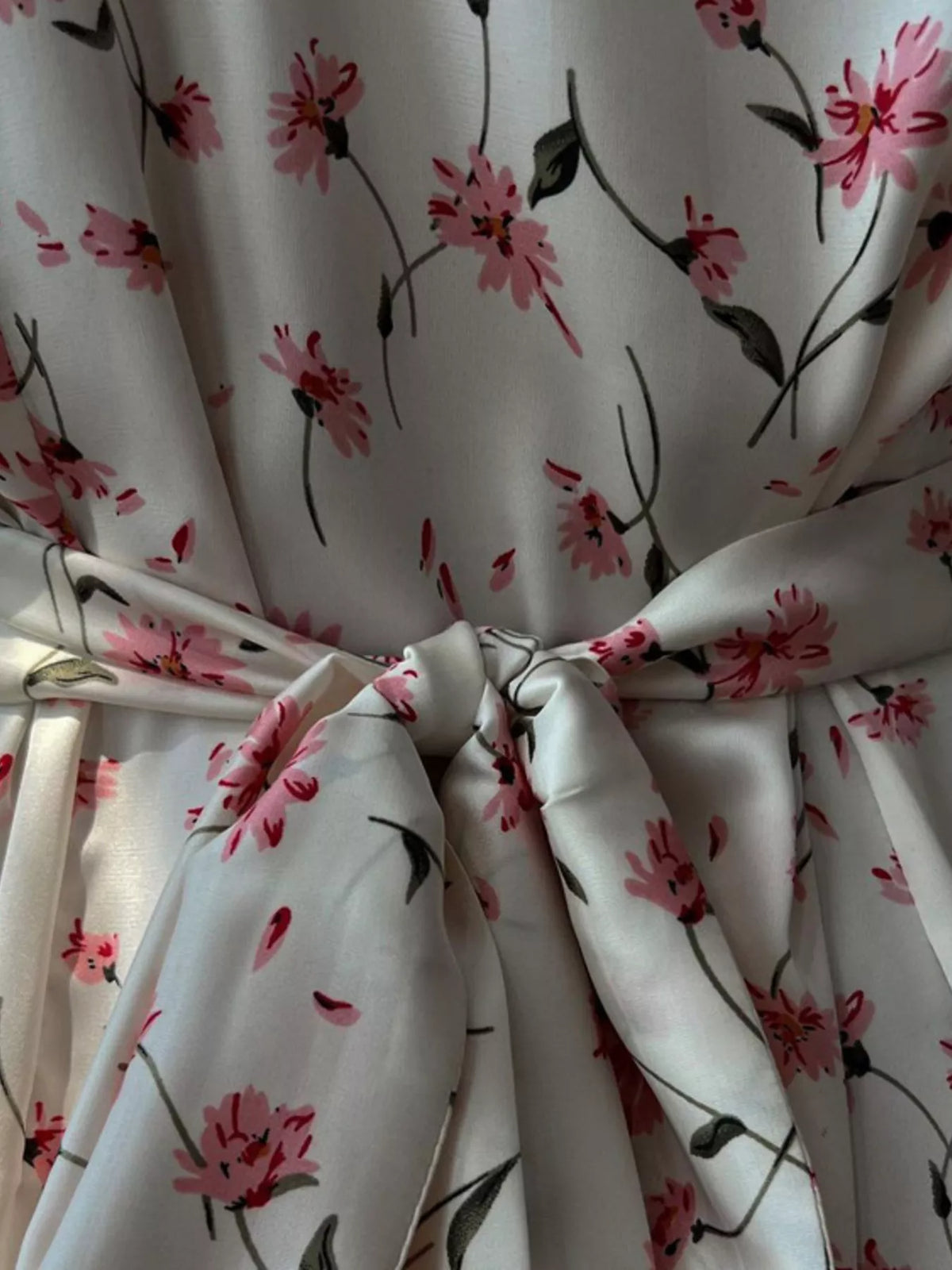 Fabric texture close up on a dusty pink floral dress