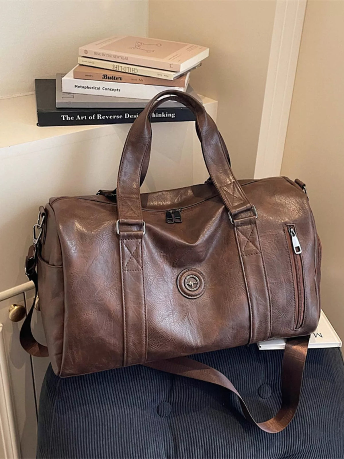 Brown leather duffel bag side view