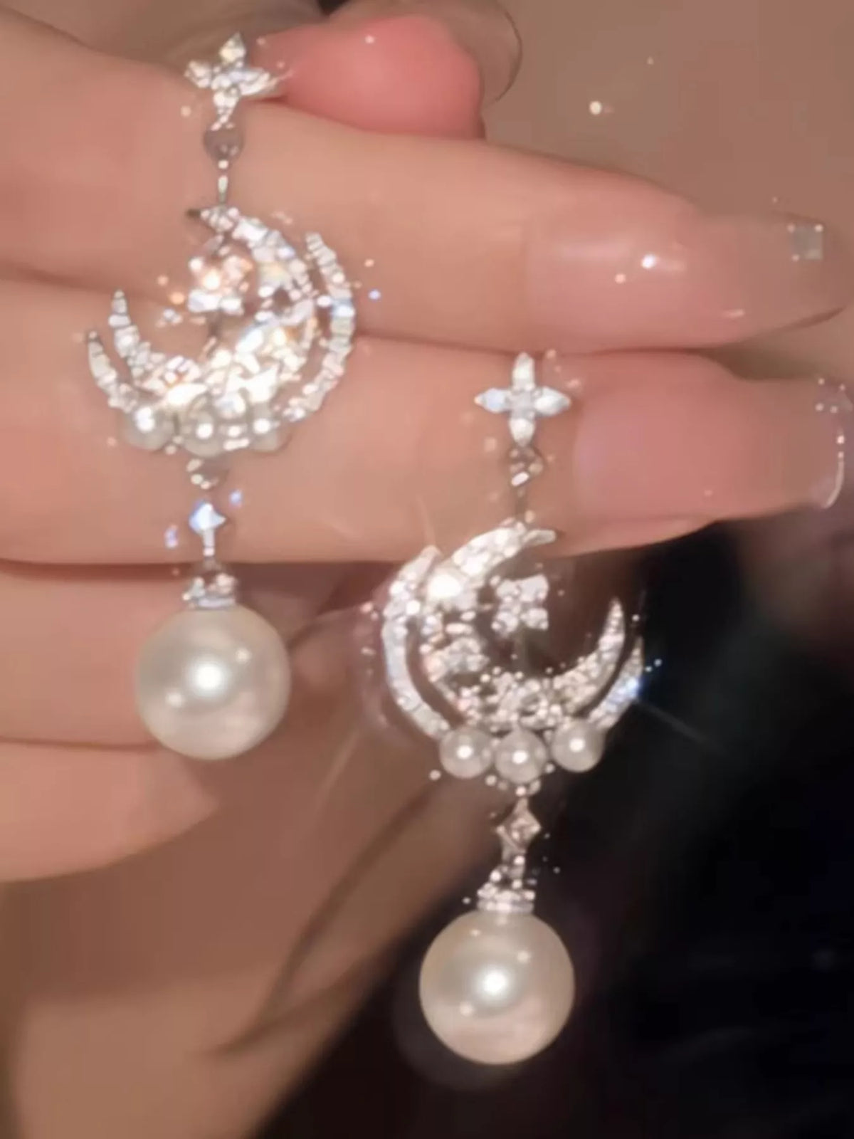 Moon and star pearl dangle earrings in silver tone, on model