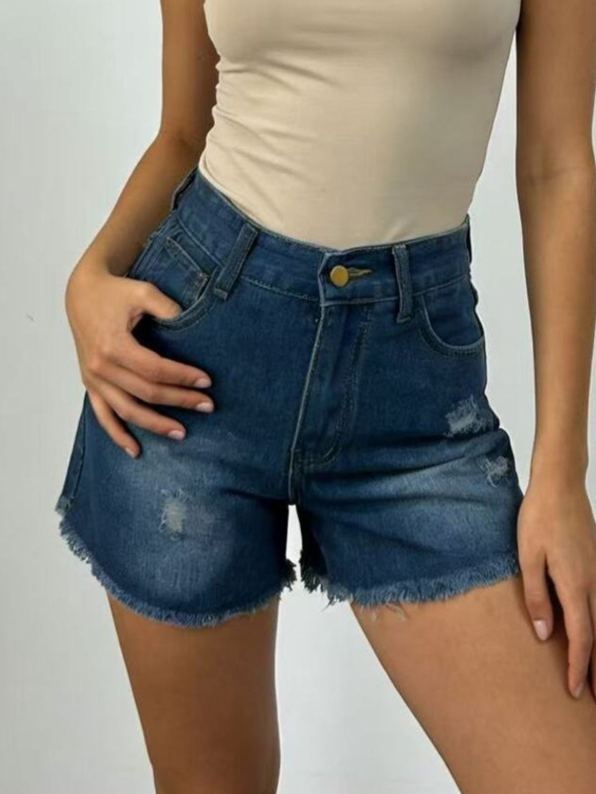 Button closure and waistband detail on the denim shorts