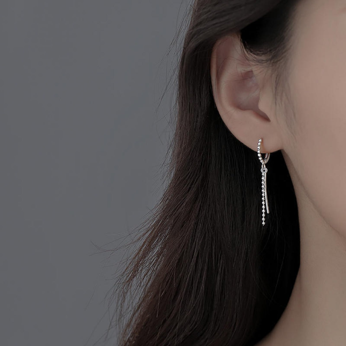 Sterling silver hoop drop earrings worn on the ear