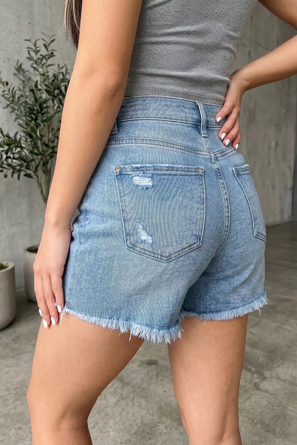 Medium wash distressed raw hem denim shorts front view