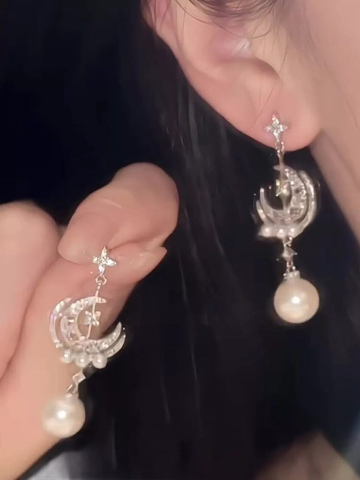 Moon and star pearl dangle earrings in silver tone, close up of the detail