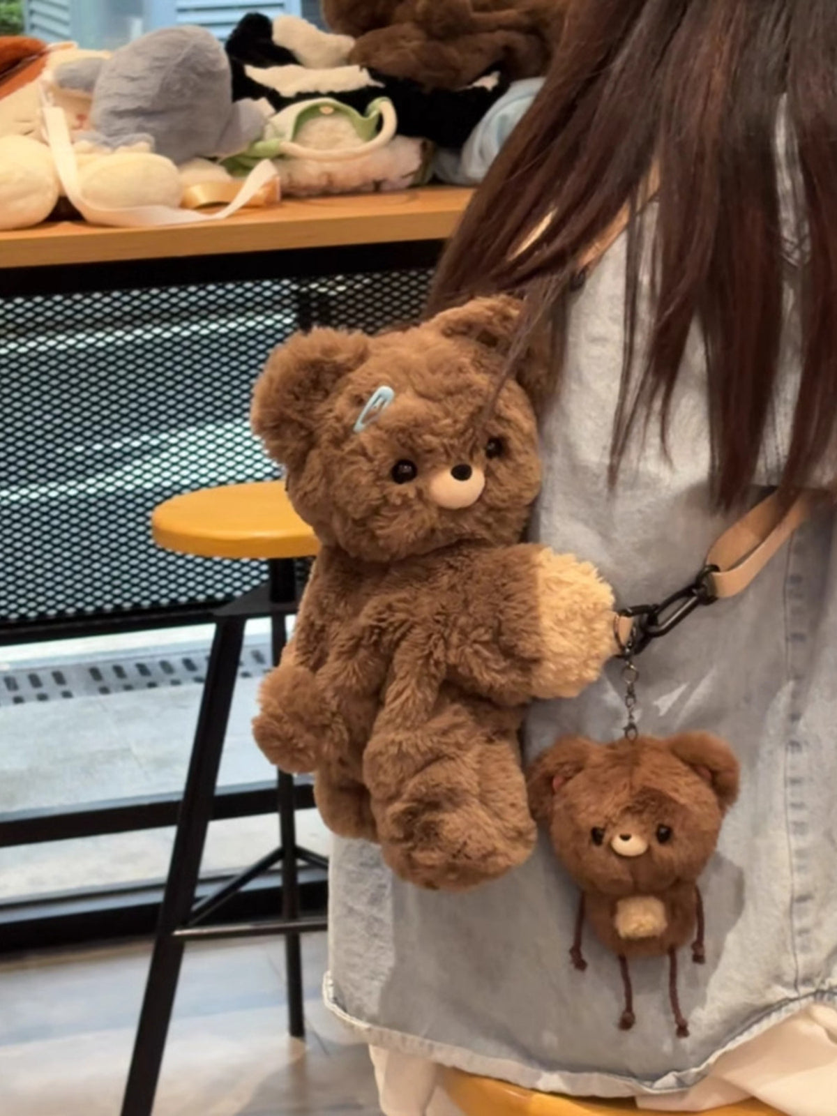 Dark brown plush teddy bear backpack flat lay styling