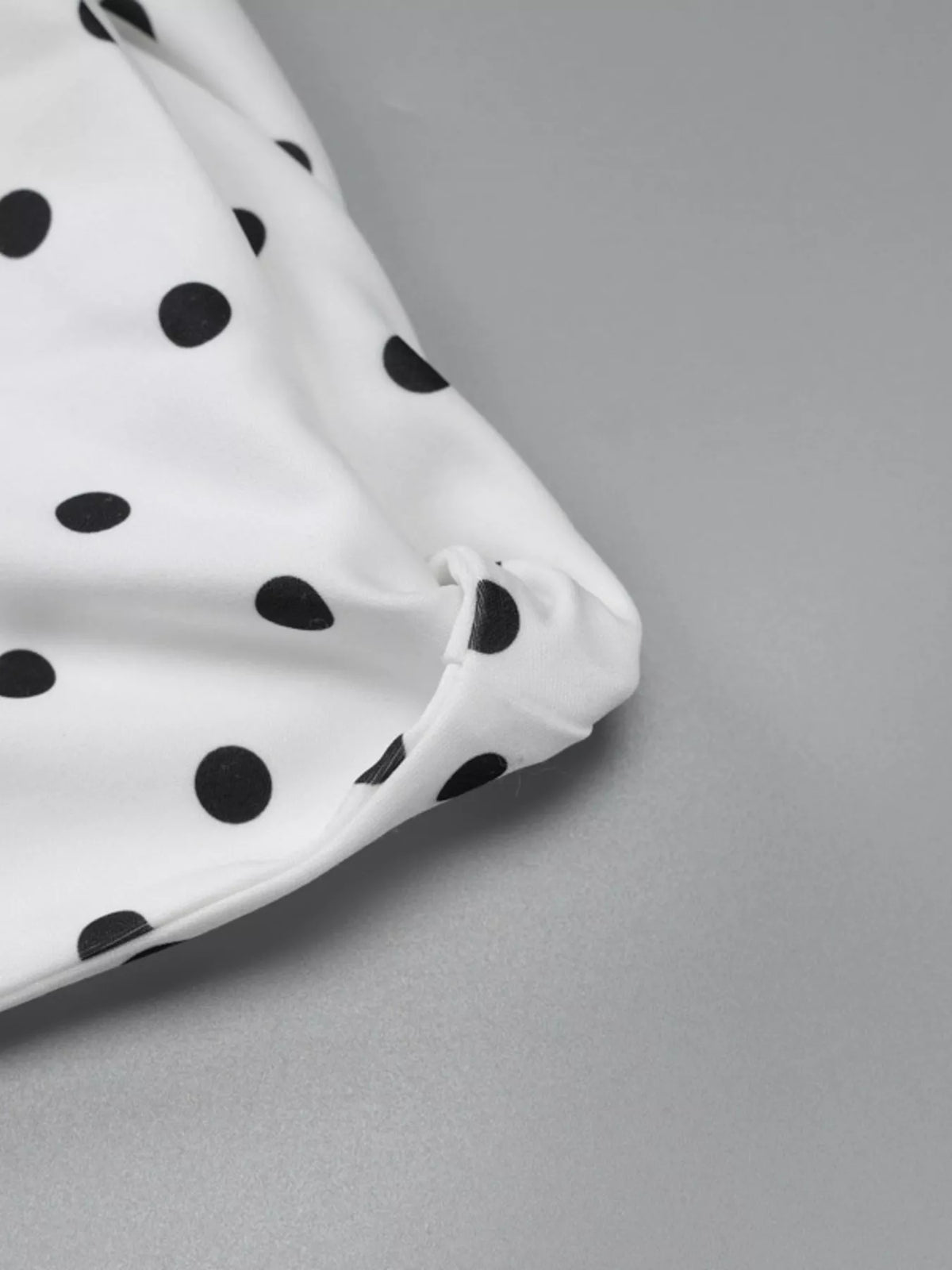 Red polka dot mini dress styled on model, three quarter angle