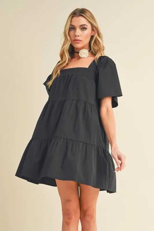 Black square neck half sleeve tiered dress front view on model