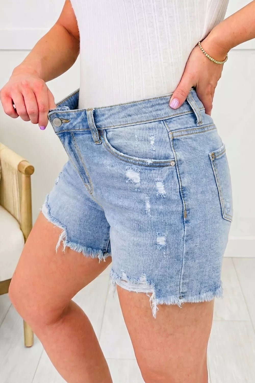 Medium wash distressed raw hem denim shorts front view