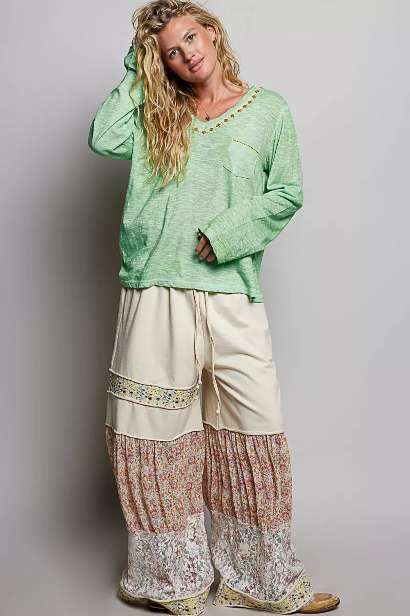 Chest pocket with contrast stitch detail on a green knit top
