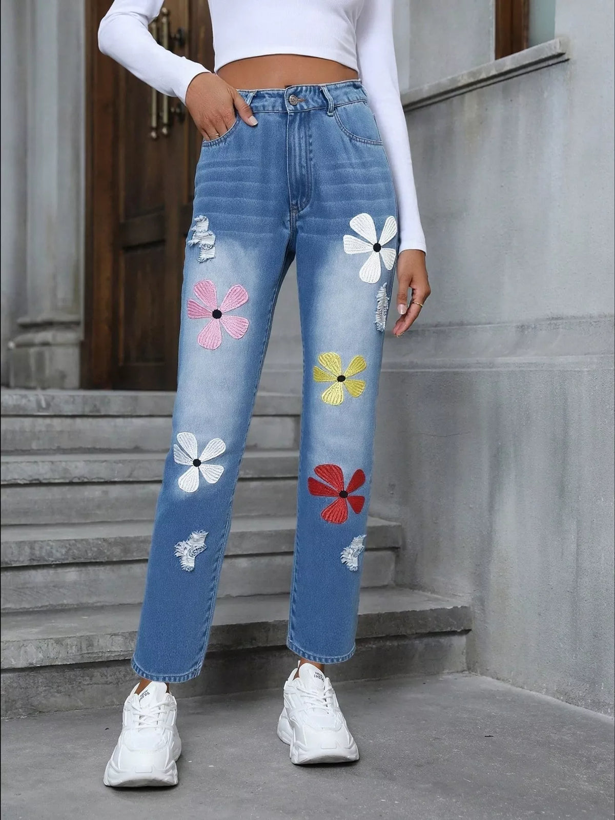 Close up of floral embroidery on blue jeans