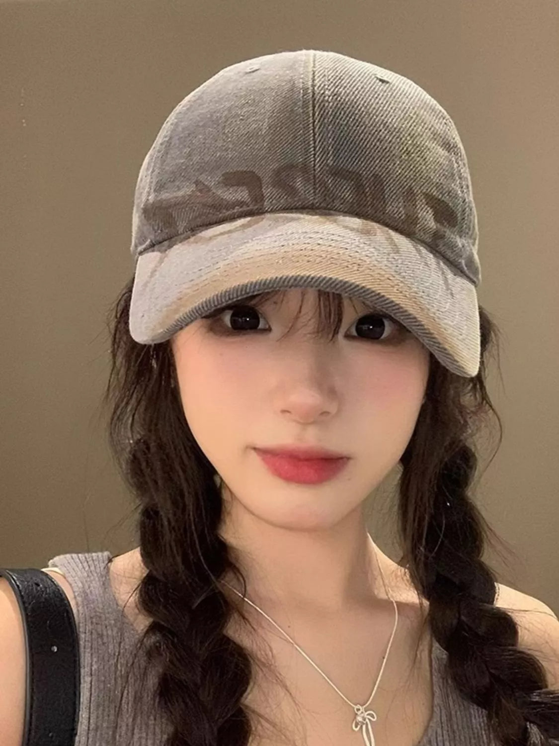 Dark gray baseball cap shown as part of a casual outfit