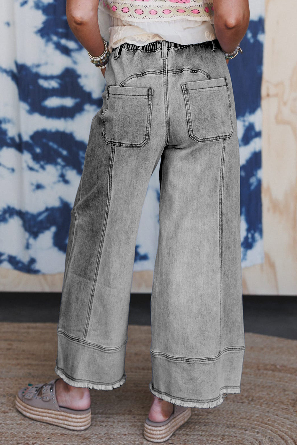 Drawstring waist detail on gray wide leg jeans