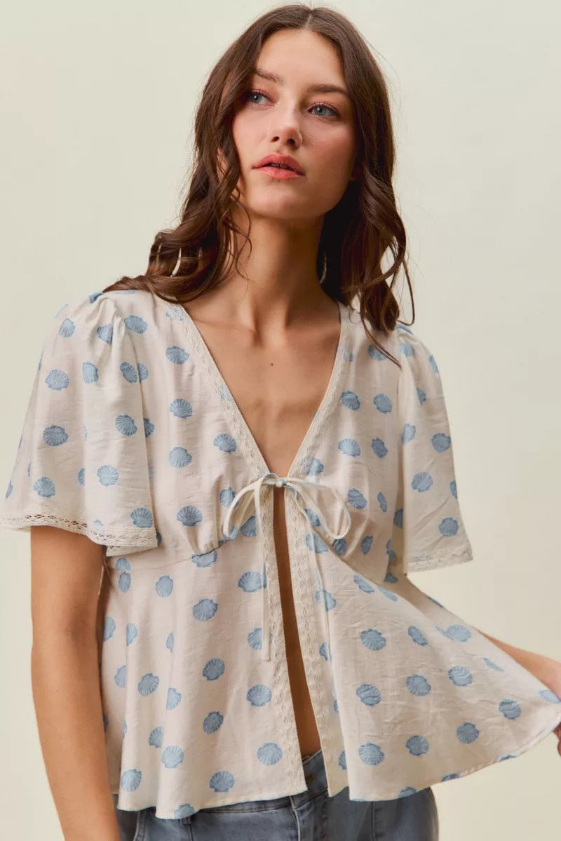 Ivory and blue shell print tie front flutter sleeve blouse front view