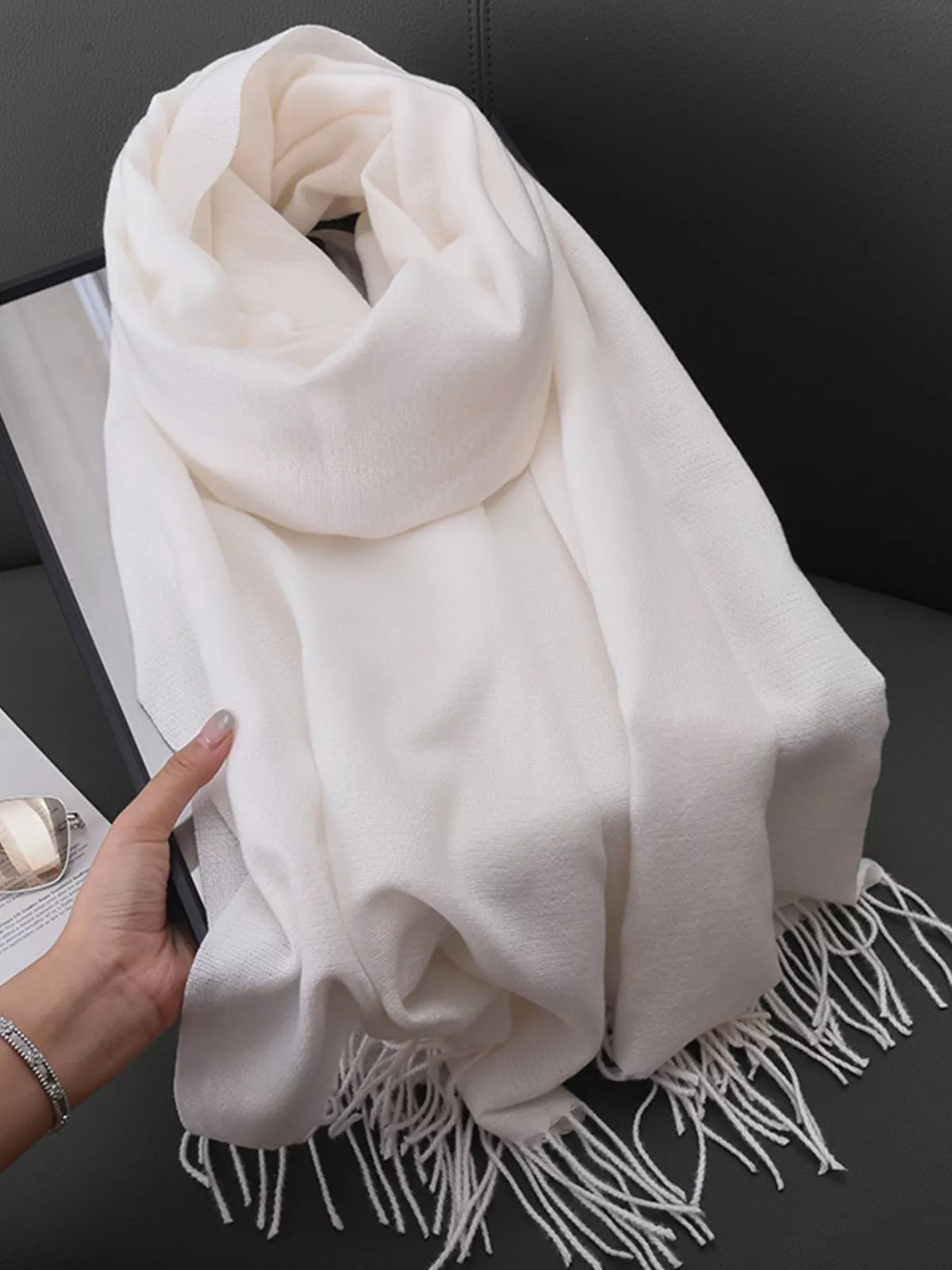 Solid color fringe scarf wrapped around neck