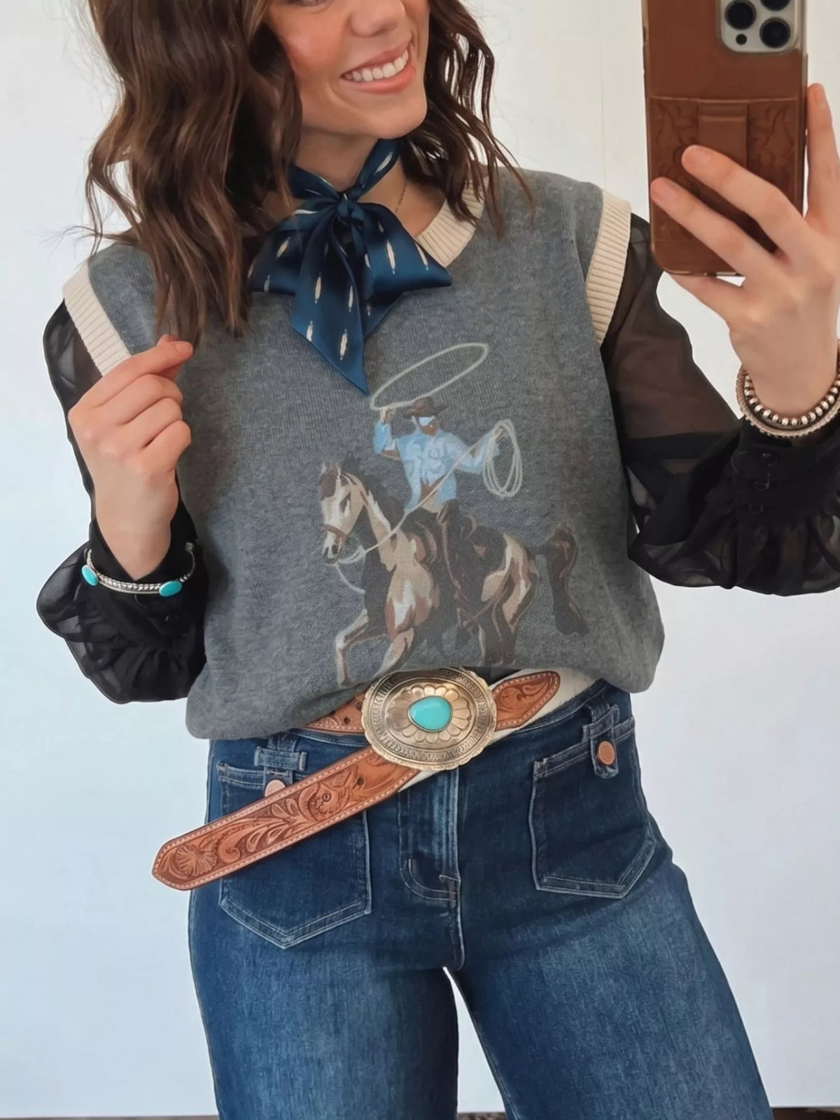 Graphic knit vest styled with jeans