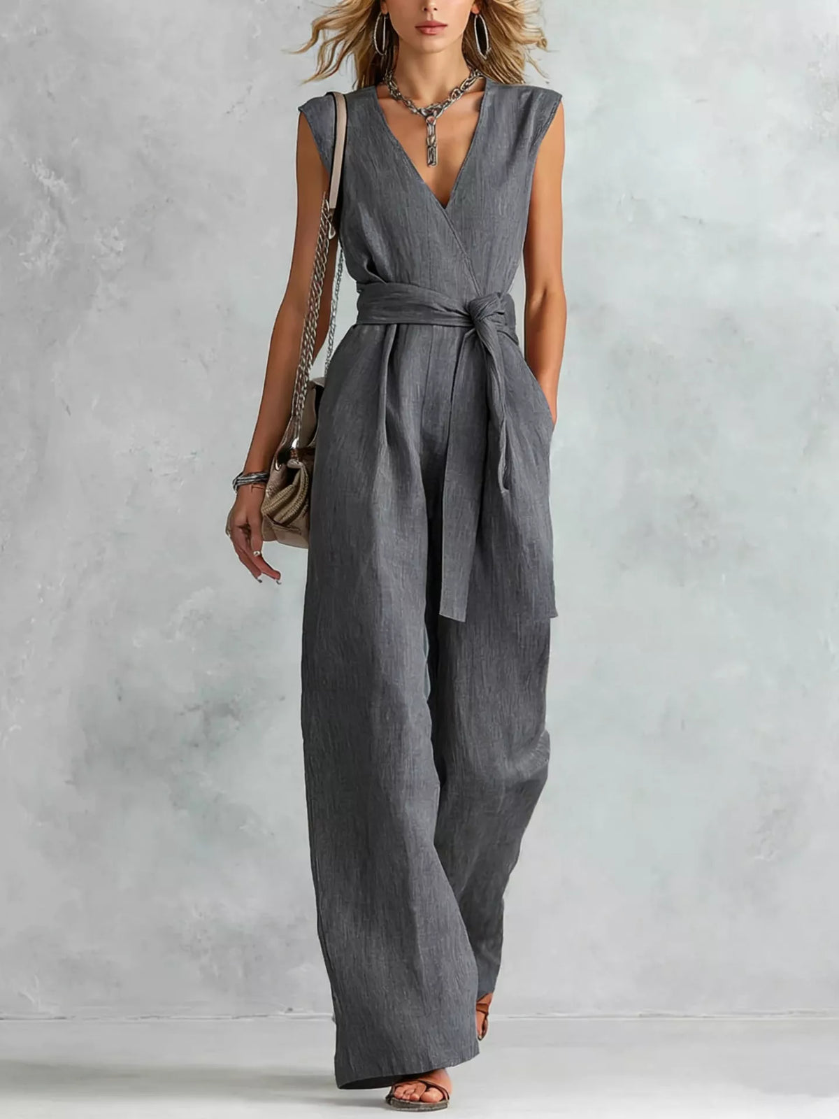 Model wearing sleeveless jumpsuit with sandals, full length