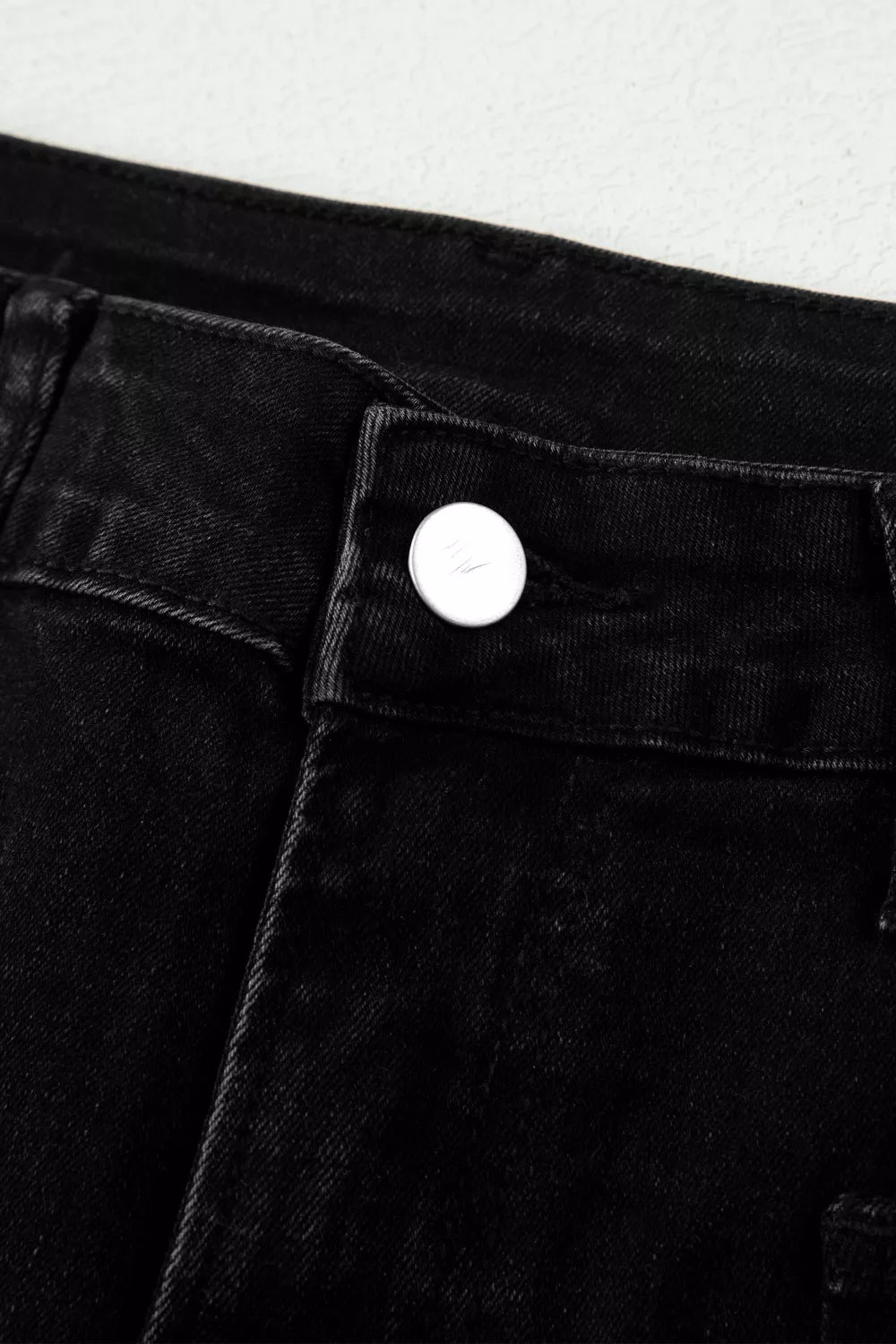 Frayed hem detail on black cropped jeans