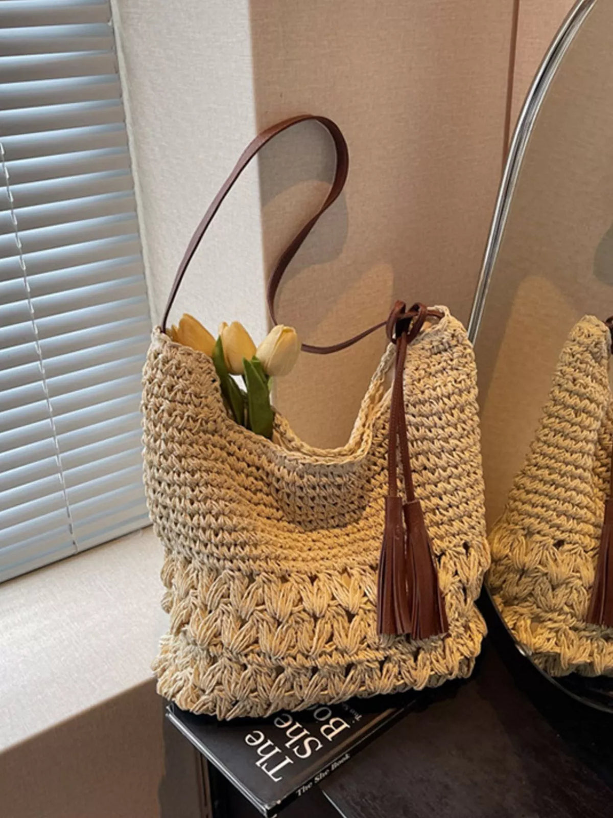 Cream white woven straw shoulder bag with tassels front view