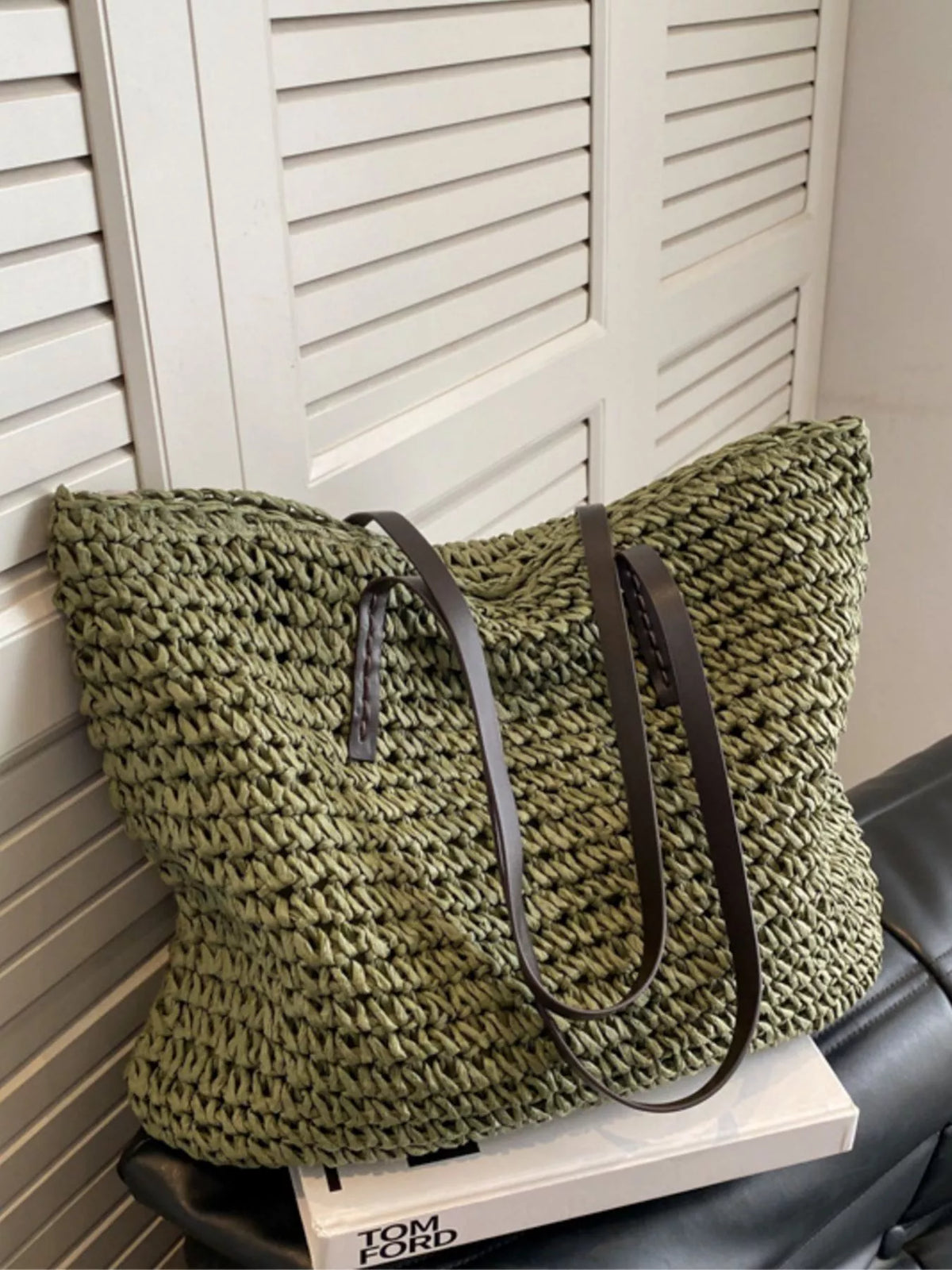 Straw shoulder bag held by model