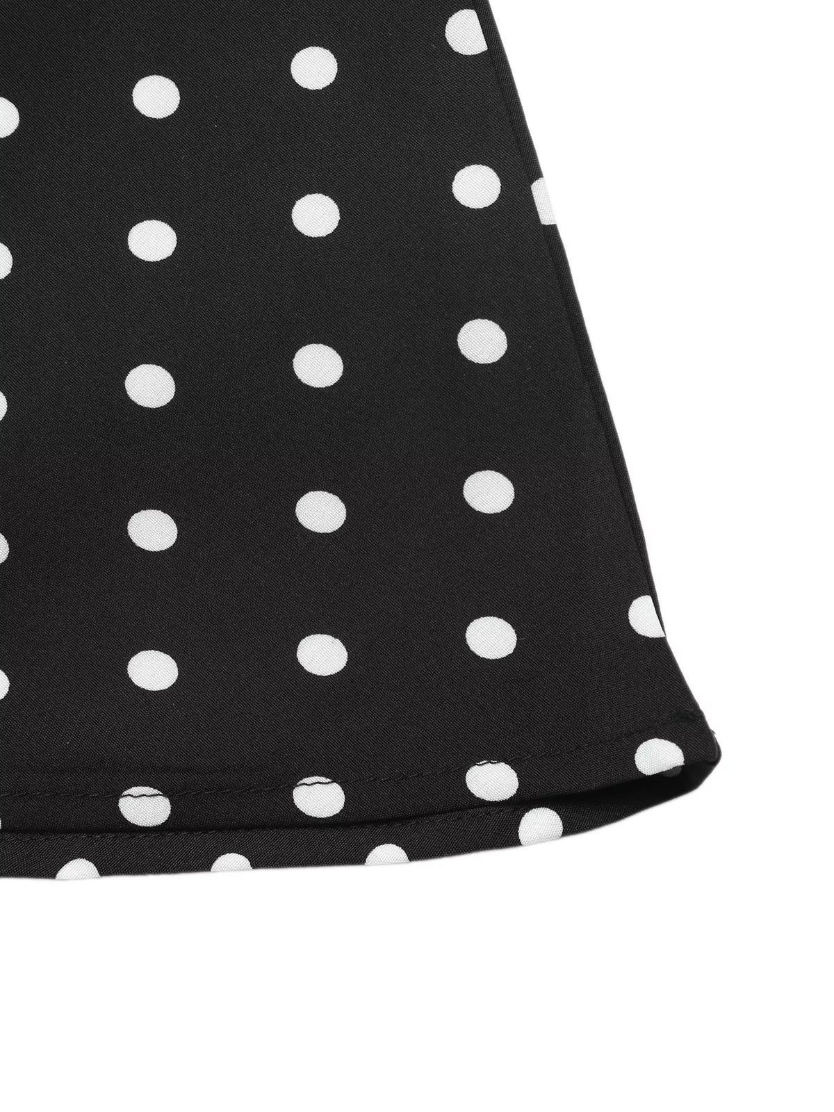 Hemline detail of the black polka dot dress
