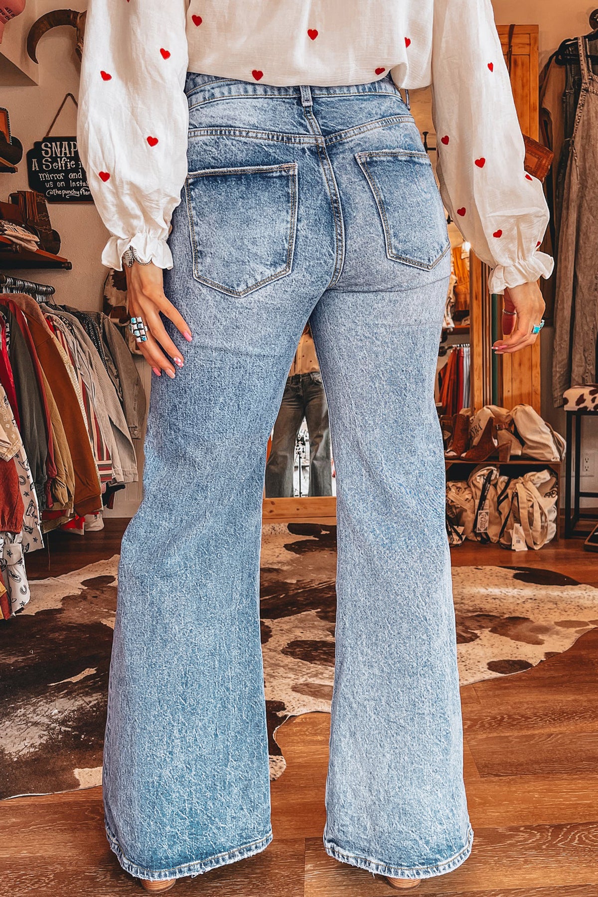 Full length view of blue wide leg acid wash flare jeans