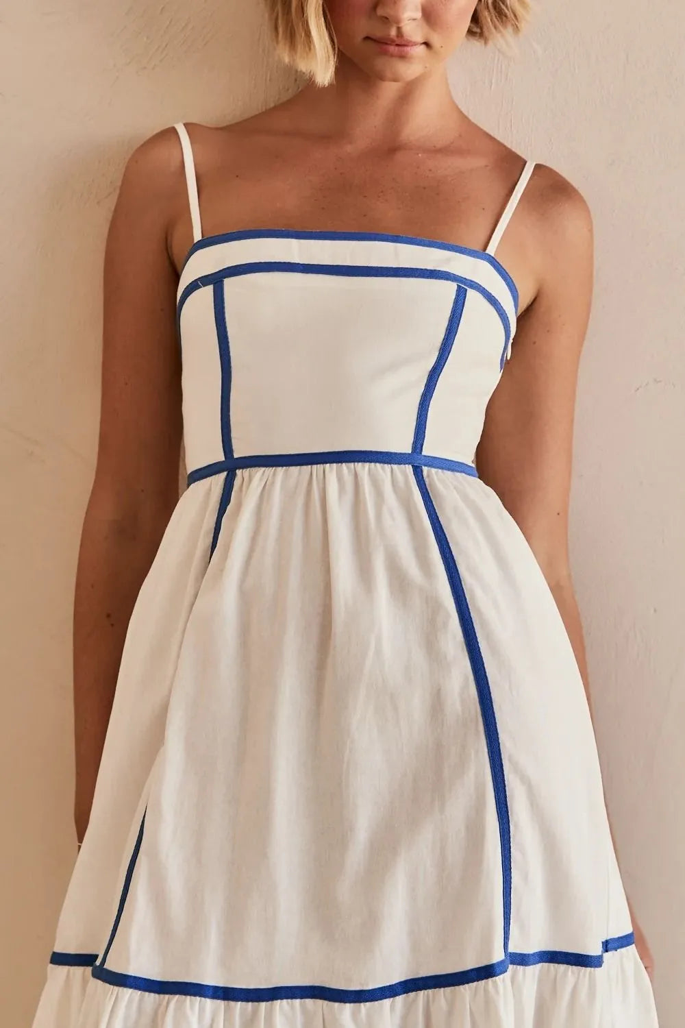 White midi dress showing contrast piping detail