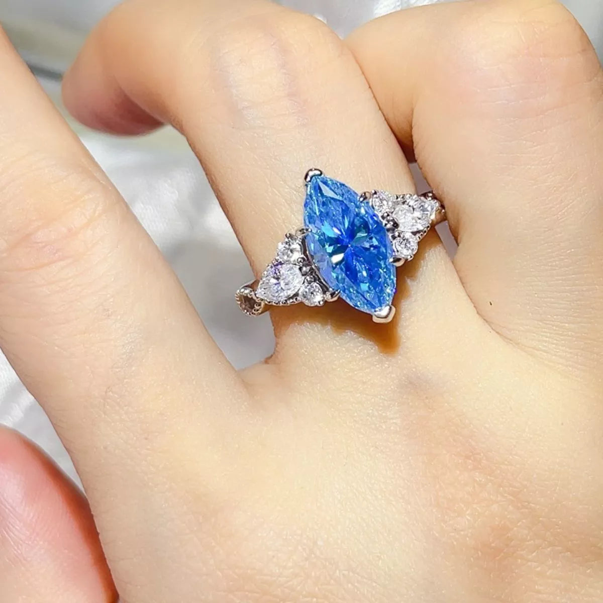 Pastel blue moissanite ring shown on a hand