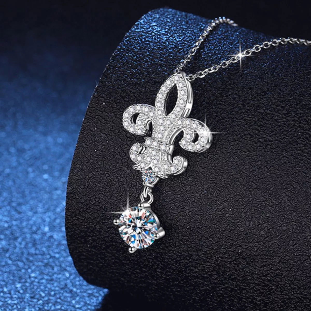 Silver iris pendant shown against a light surface