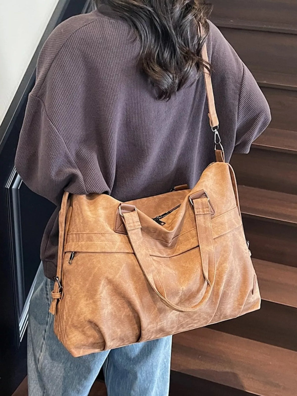Brown leather duffel bag handle detail