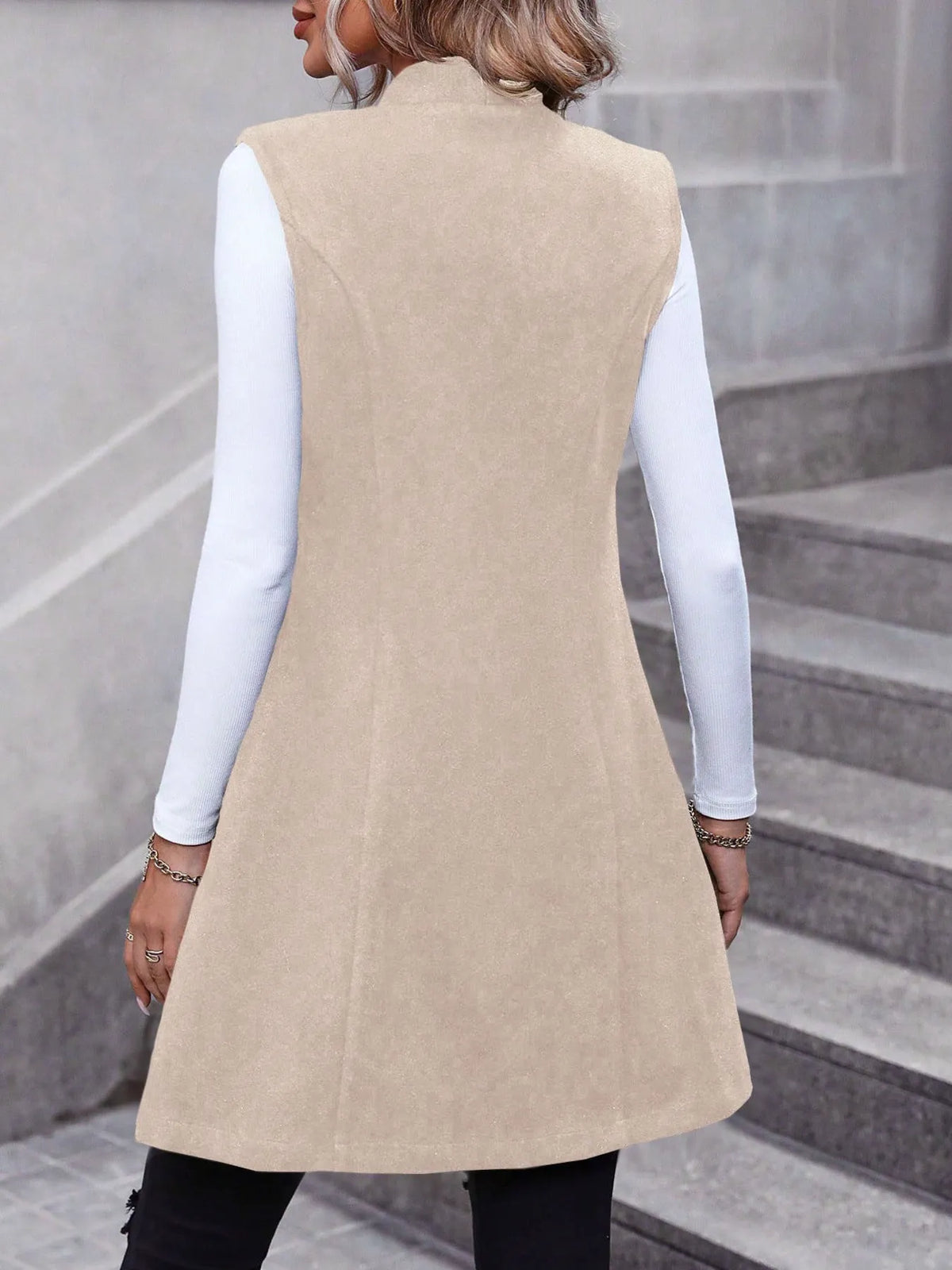 Longline vest worn open over a knit