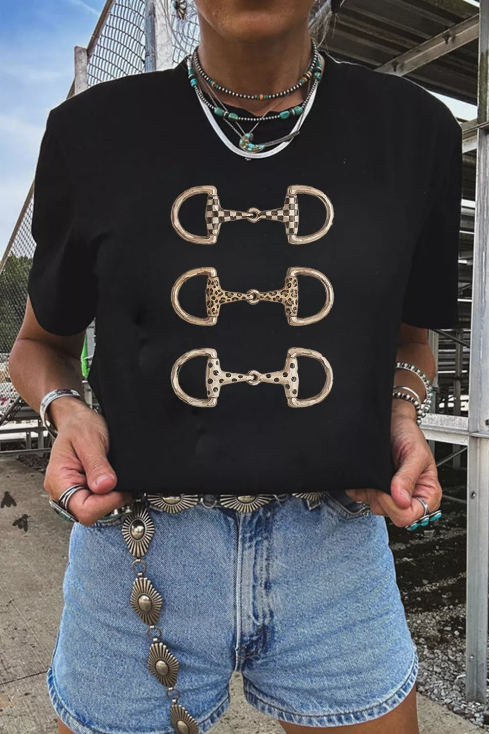 Close view of the horse bit print detail on the black tee