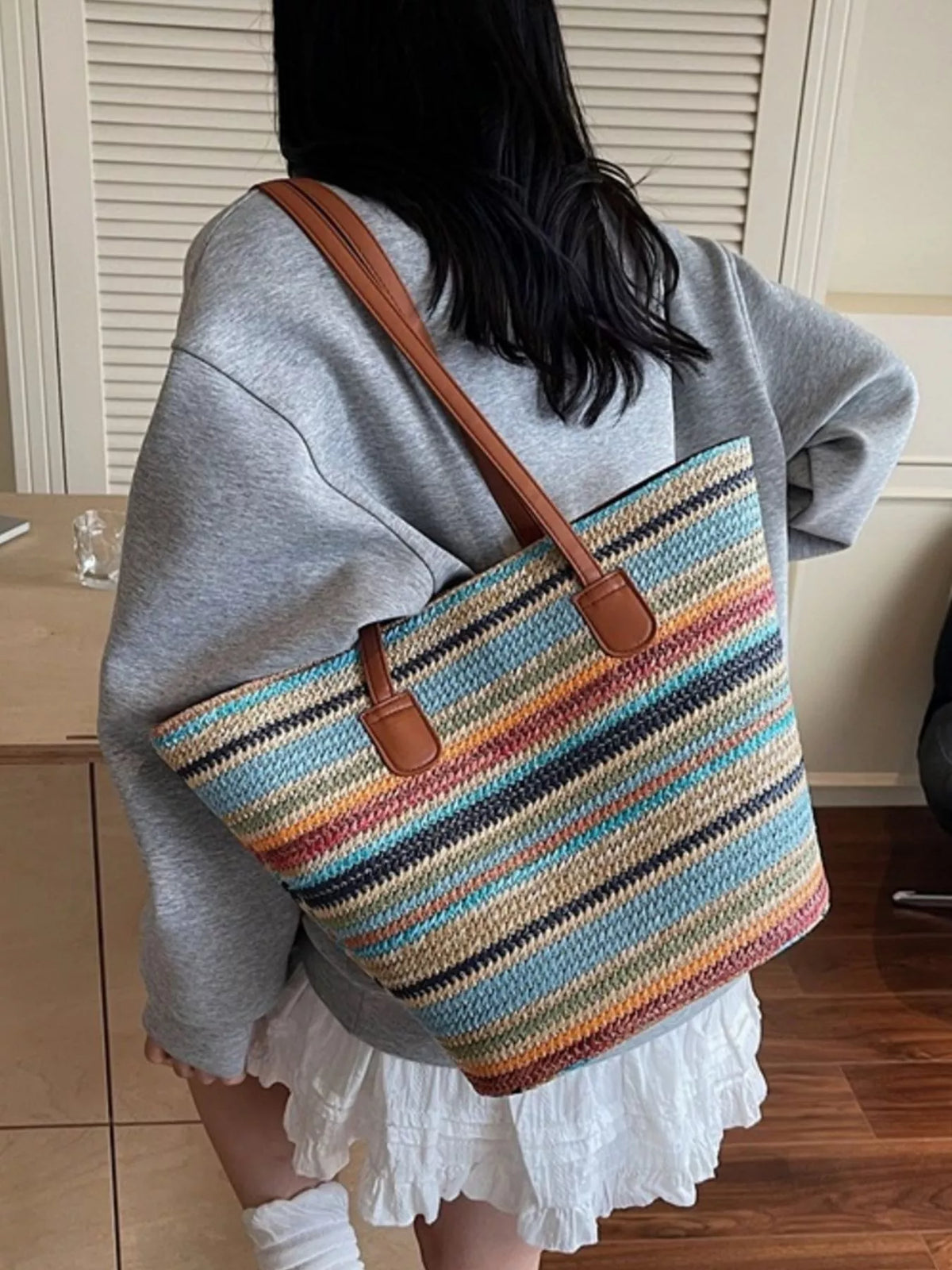 Straw shoulder bag held by model