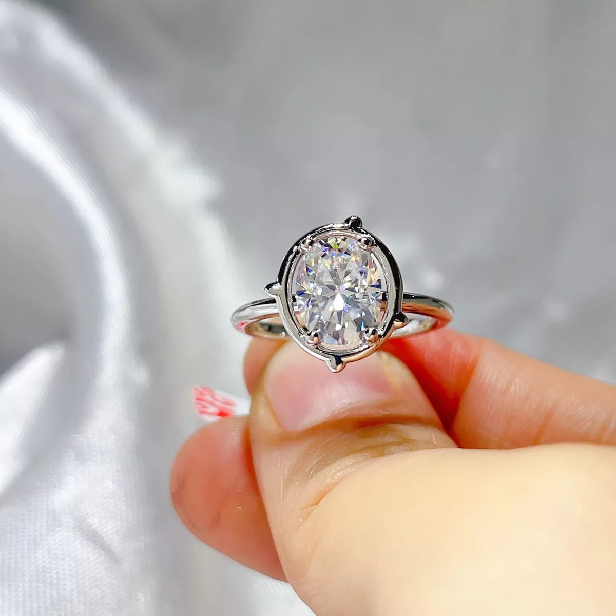 Close up of the 2 carat oval moissanite stone and slim silver band