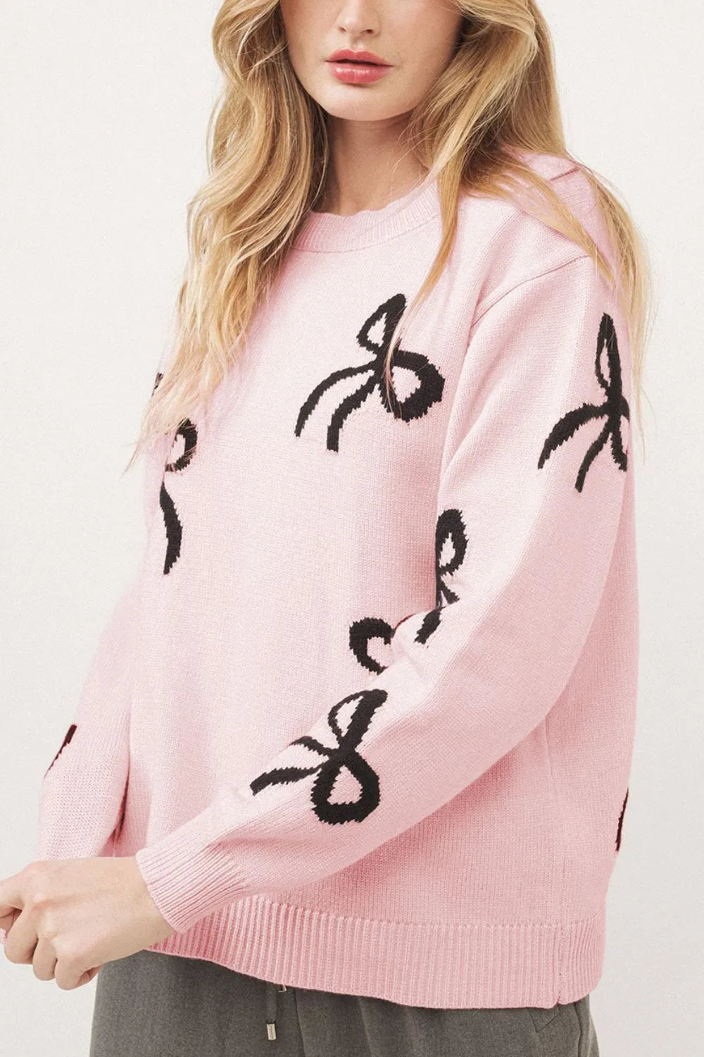 Blush pink bow sweater shown on model