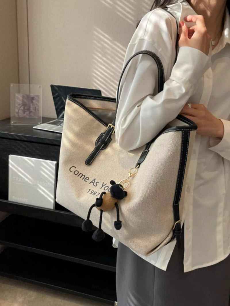 Tan canvas tote bag with charm front view