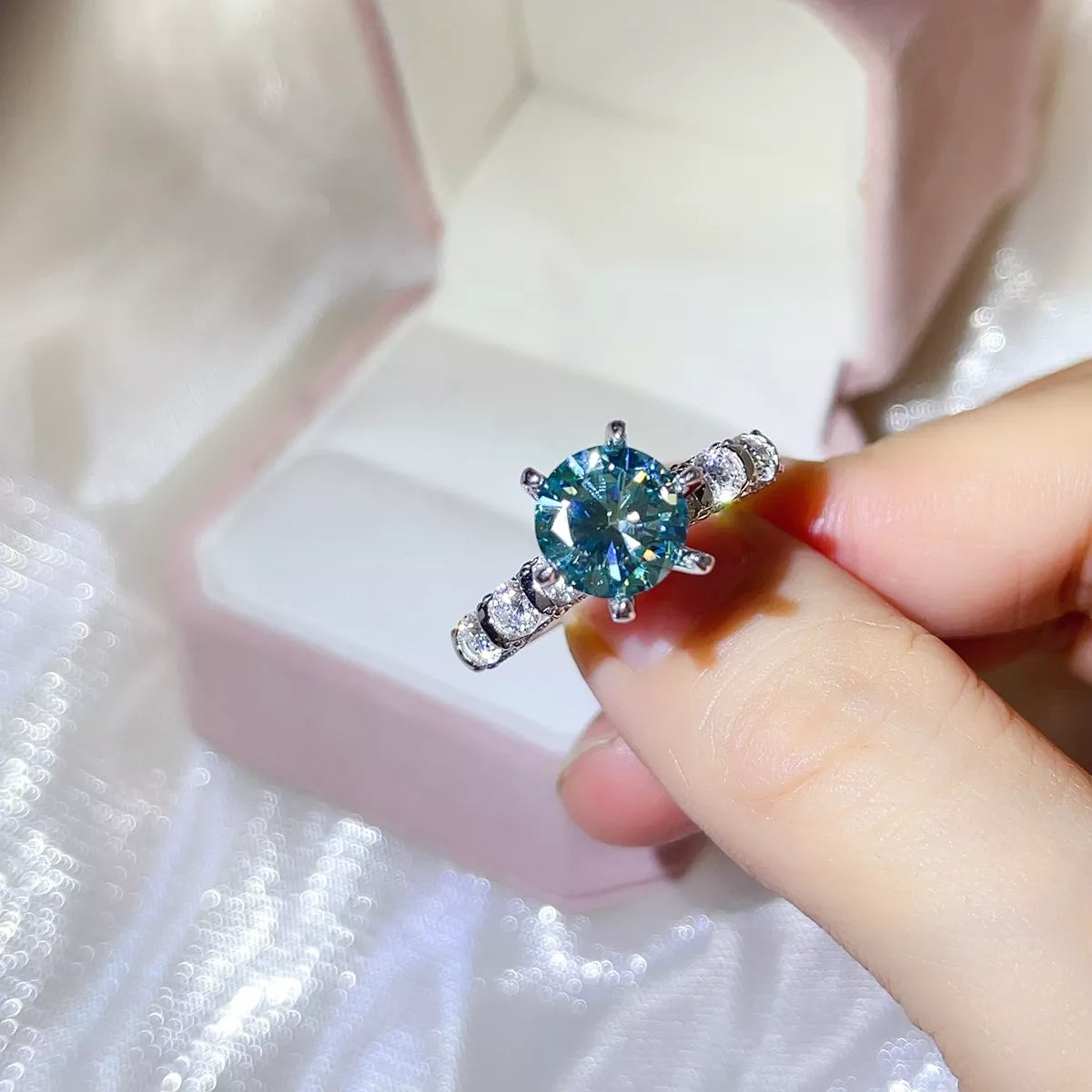 Turquoise moissanite ring shown at an angle to display the setting