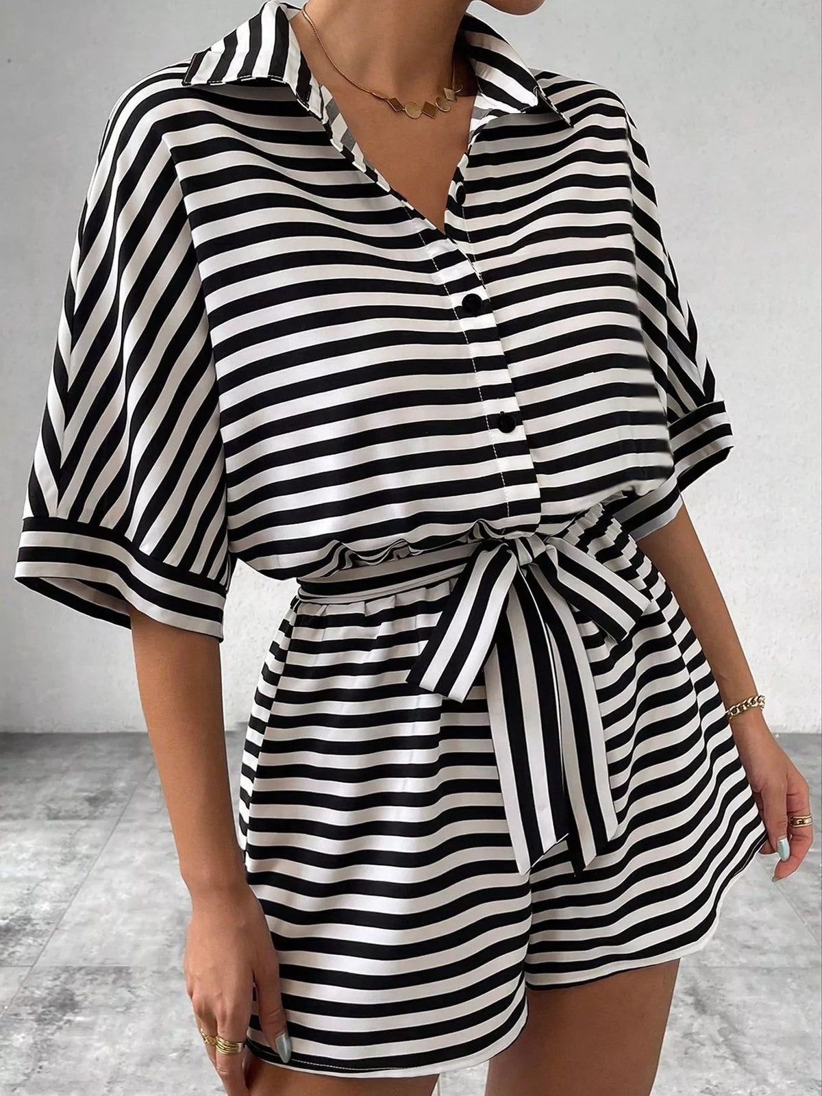 Striped button up belted romper in black, front view