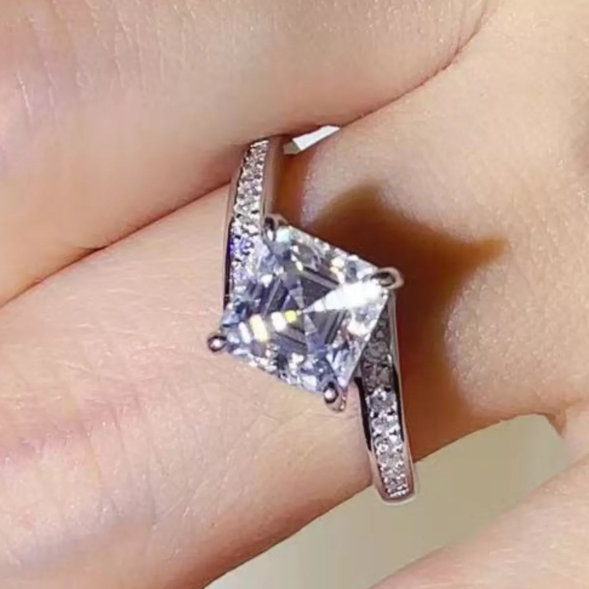 Moissanite ring shown on a hand from the front